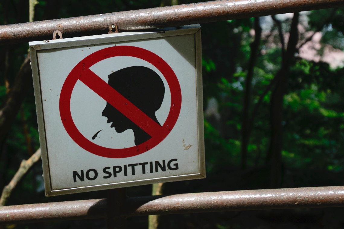 No spitting sign tied on a fence